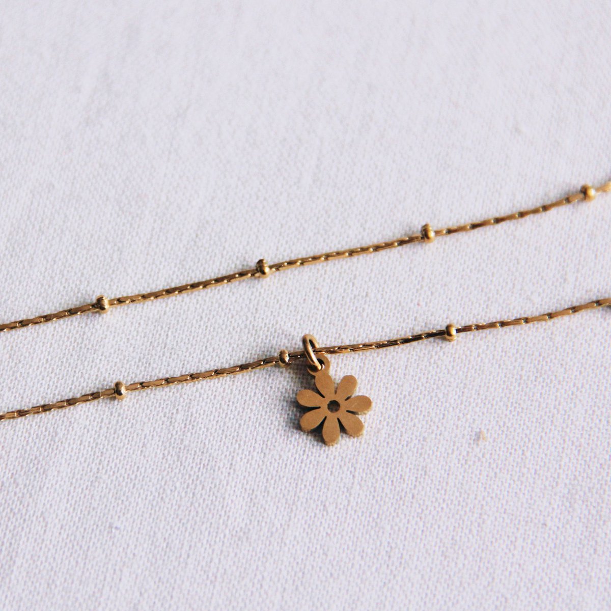 Fijn enkelbandje van roestvrij staal met madeliefjebloem β goud